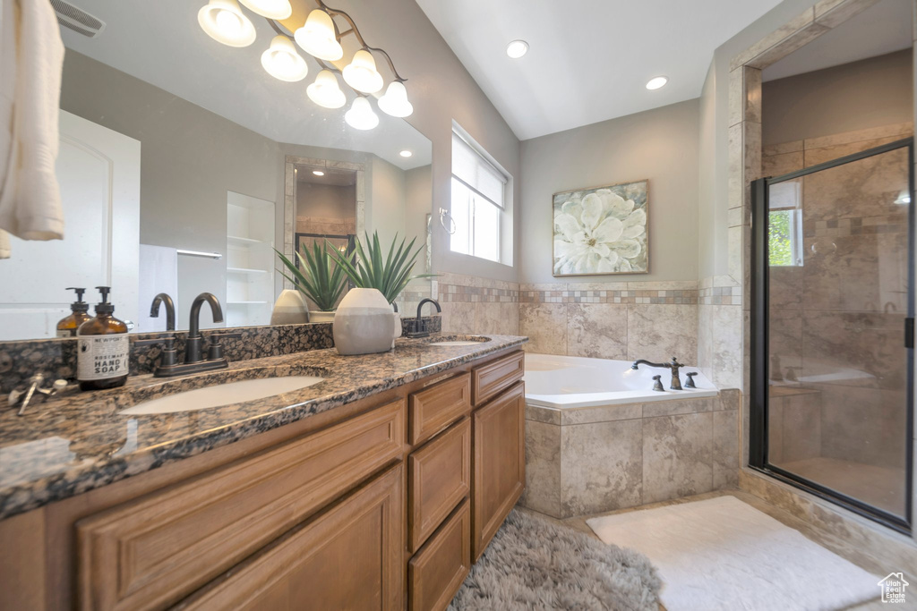 Bathroom with a bath, double vanity, a shower stall, and recessed lighting