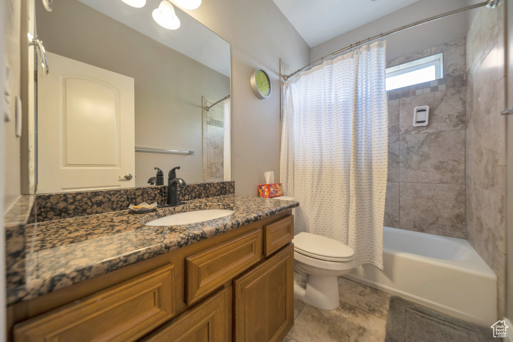 Bathroom with toilet, shower / tub combo with curtain, vanity, and tile patterned floors