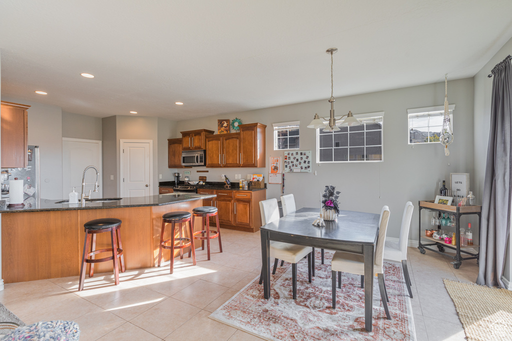 Dining area with light tile patterned floors, recessed lighting, and a chandelier