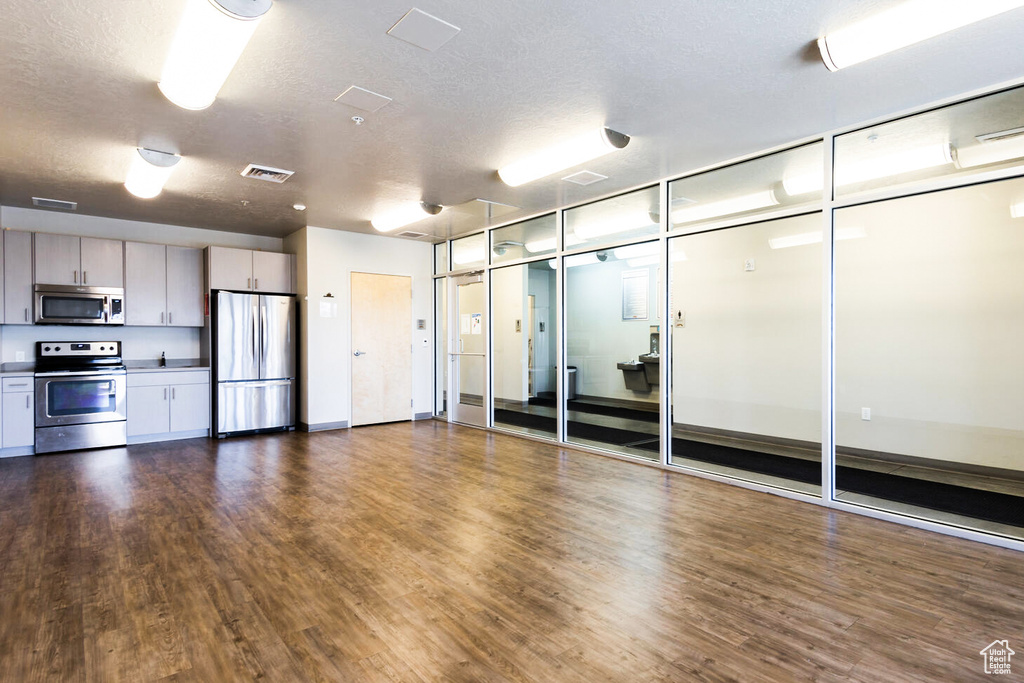 Empty room featuring a textured ceiling and dark wood-style floors
