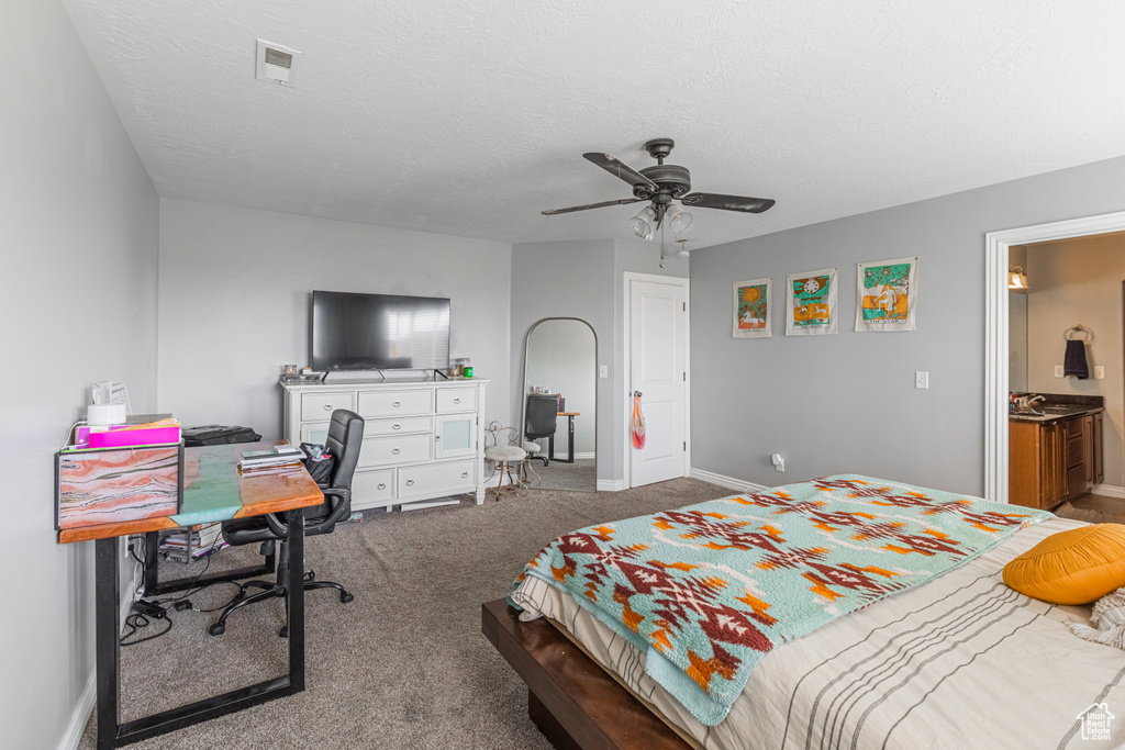 Bedroom featuring a desk, carpet, baseboards, ceiling fan, and a textured ceiling