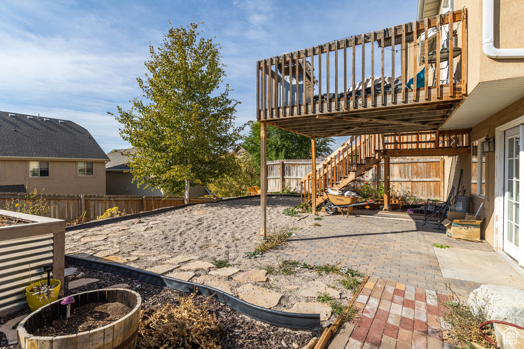 Fenced backyard featuring a patio area, stairway, and a wooden deck