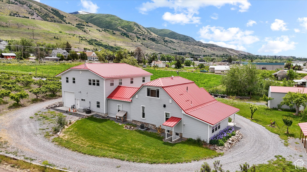 Aerial view of property and surrounding area with a mountainous background