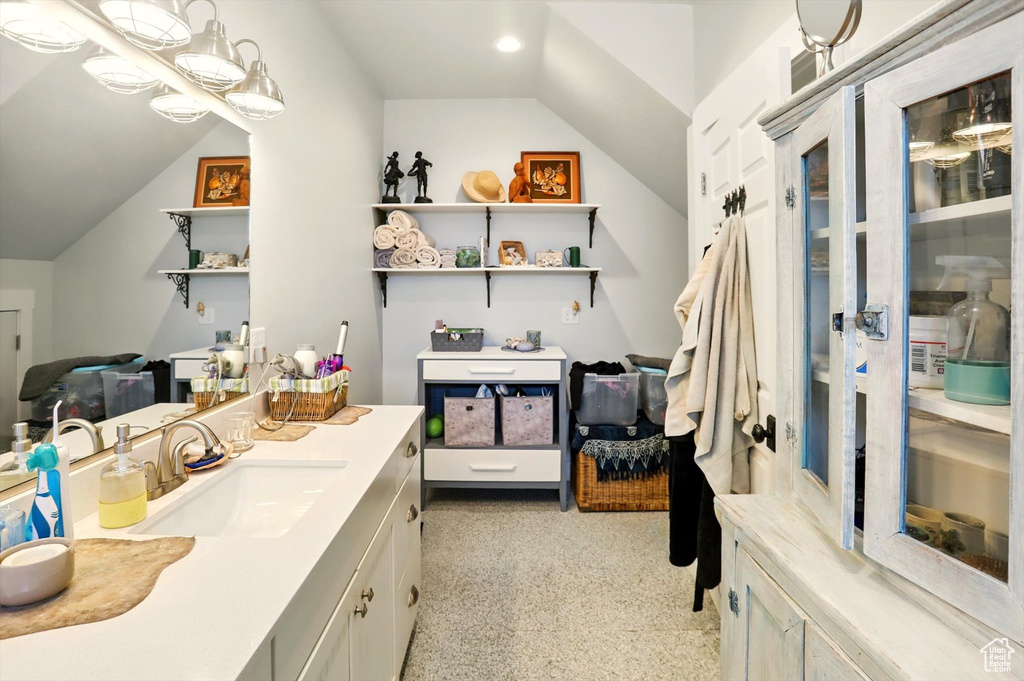 Bathroom featuring vaulted ceiling and vanity