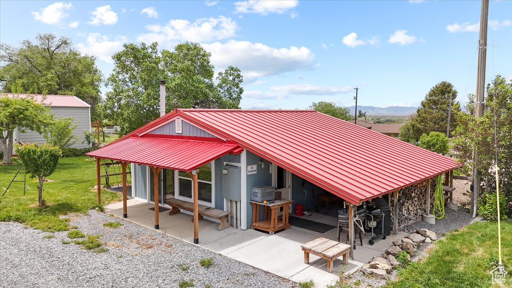 View of home's community featuring a patio, a lawn, and a mountain view