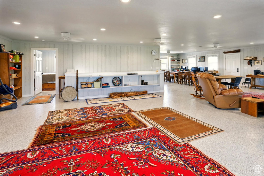 Living area with ceiling fan, recessed lighting, and speckle patterned floor