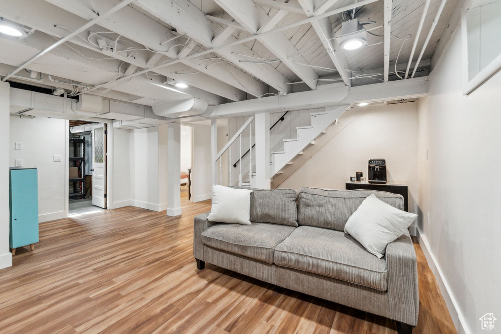 Living room with wood finished floors, baseboards, and stairs