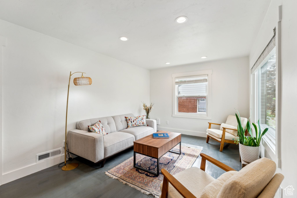 Living area with wood finished floors, baseboards, and recessed lighting