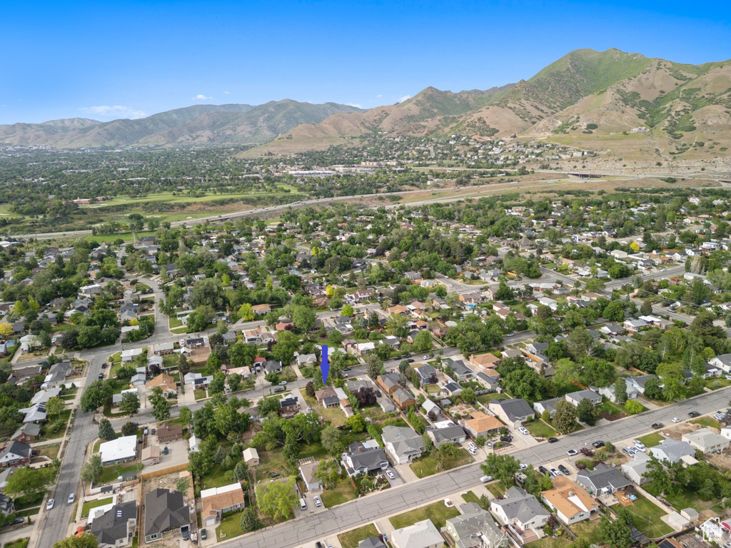 Aerial view of property and surrounding area with mountains and nearby suburban area