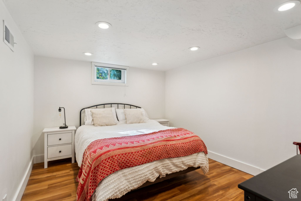 Bedroom featuring wood finished floors, recessed lighting, and baseboards