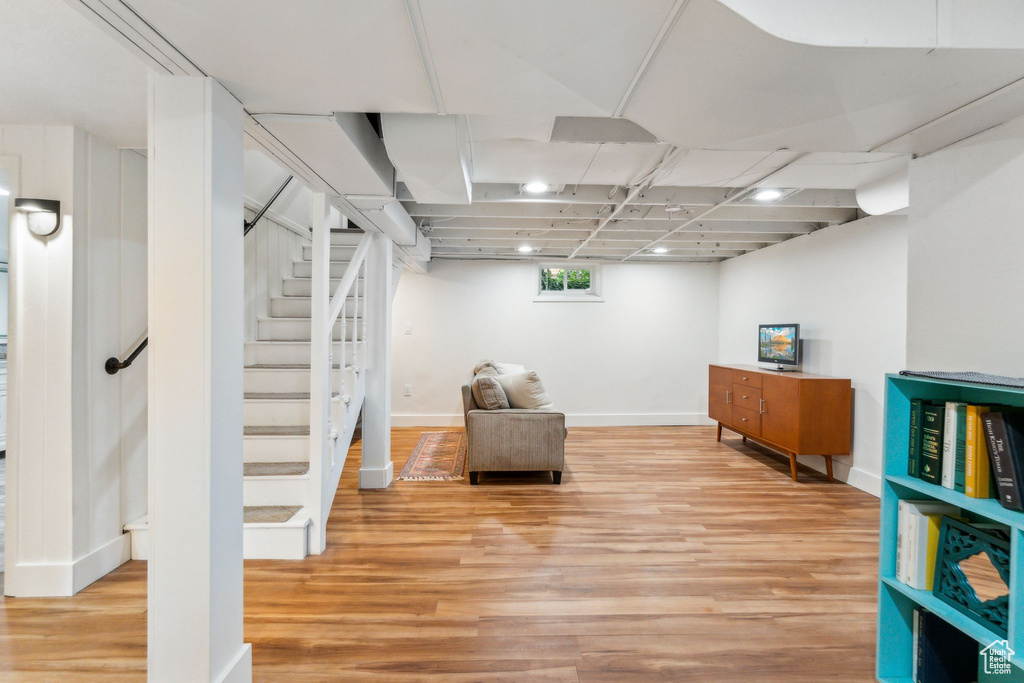 Below grade area featuring light wood-style flooring, stairway, baseboards, and recessed lighting