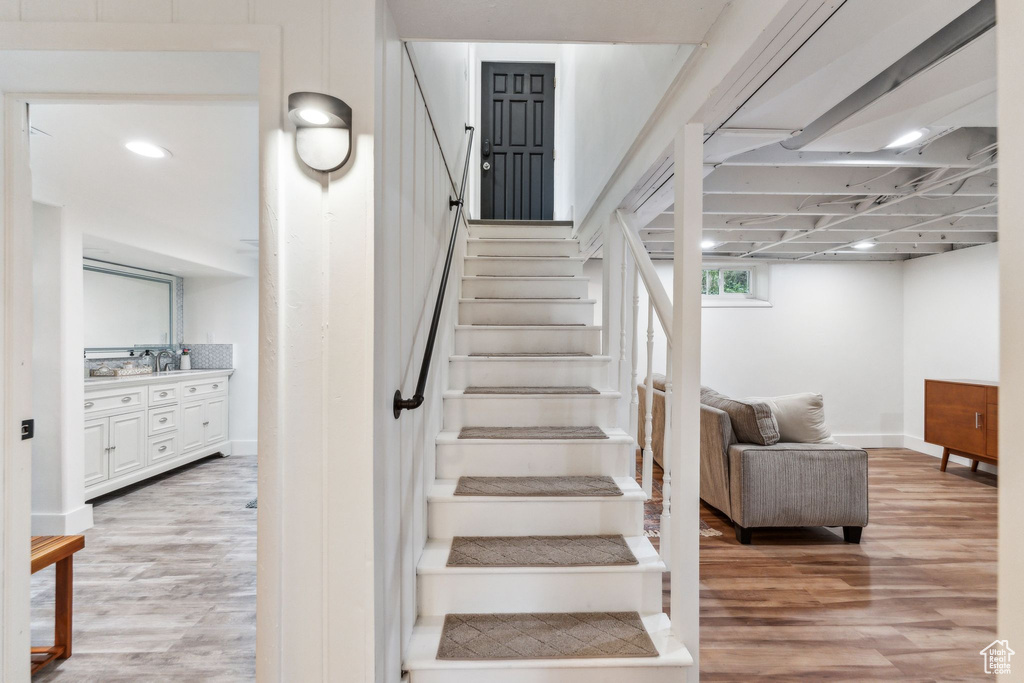 Staircase with wood finished floors and baseboards