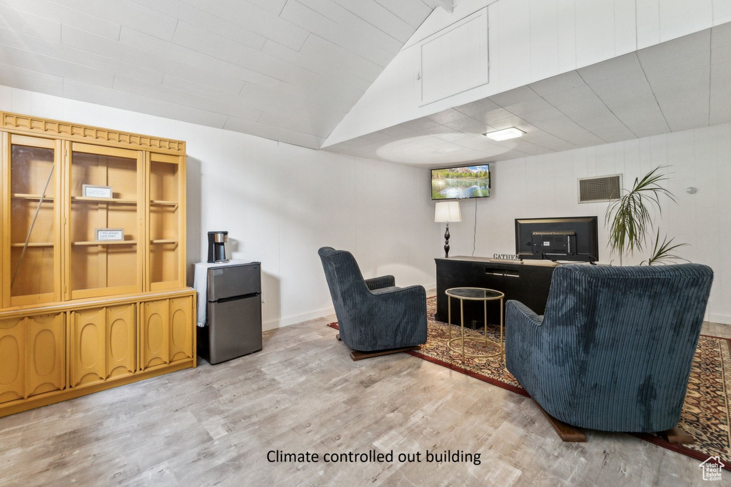 Living room featuring light wood finished floors and vaulted ceiling