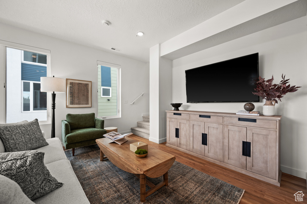 Living area with stairway, dark wood-style floors, recessed lighting, and baseboards