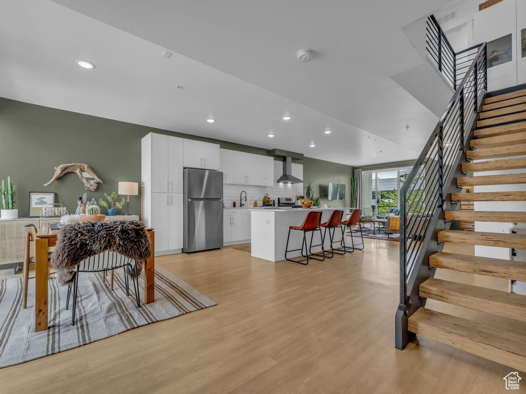 Dining room featuring recessed lighting, light wood-style floors, and stairs
