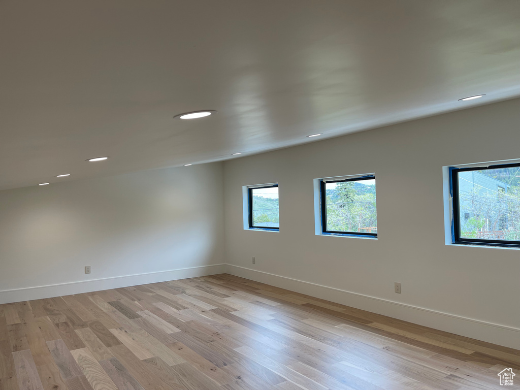 Empty room with light wood finished floors, baseboards, and recessed lighting