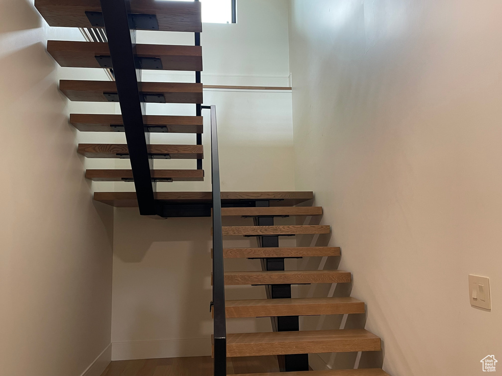 Stairs with wood finished floors and baseboards