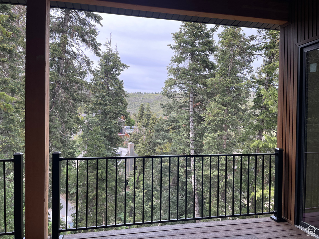 Balcony featuring a forest view