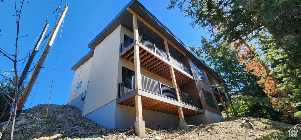 View of side of property with a balcony and stucco siding