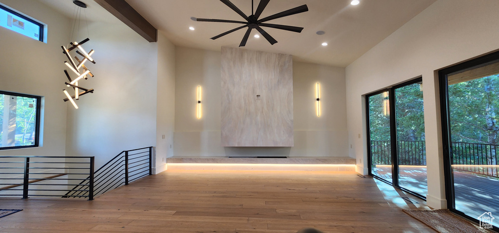 Corridor with wood finished floors, an upstairs landing, recessed lighting, and high vaulted ceiling