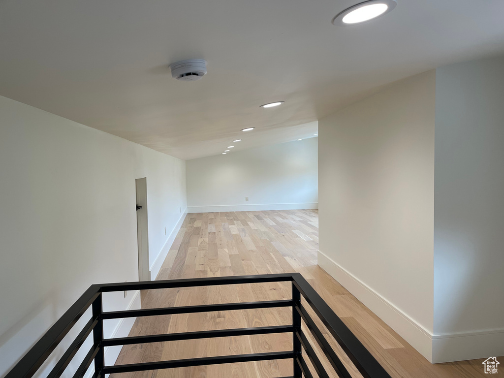 Hall with light wood finished floors, baseboards, and recessed lighting
