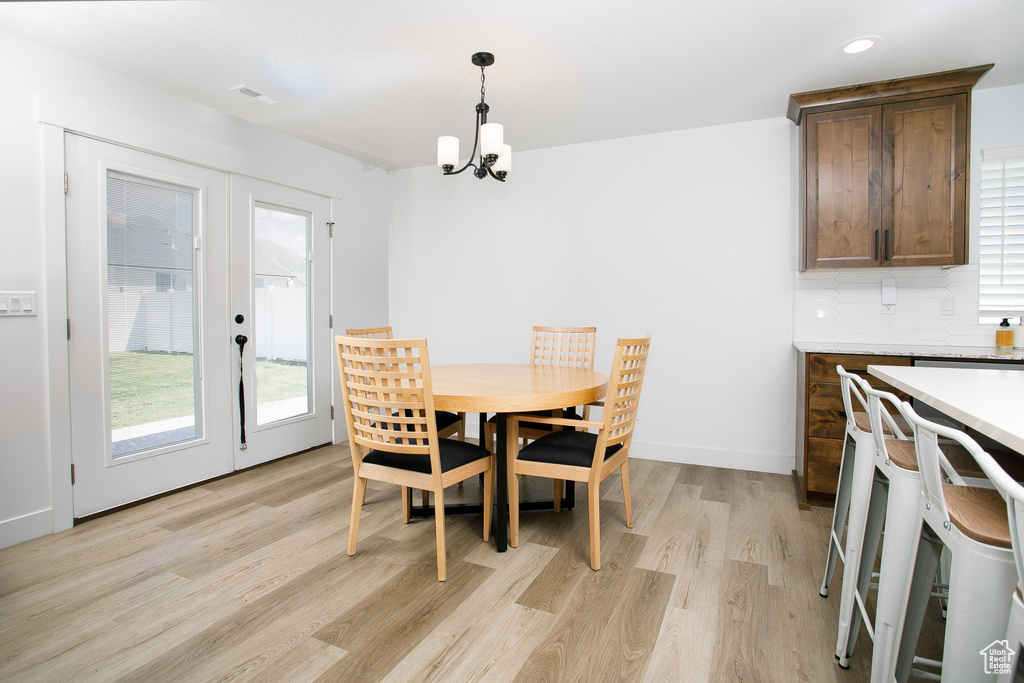 Dining area with french doors, light wood-type flooring, a chandelier, and recessed lighting