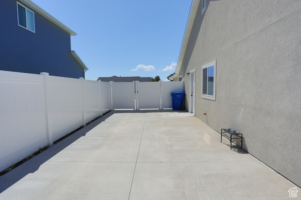 Fenced backyard featuring a gate and a patio