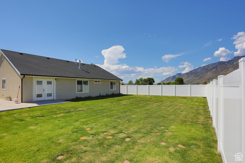 View of yard with french doors, a mountain view, and a patio