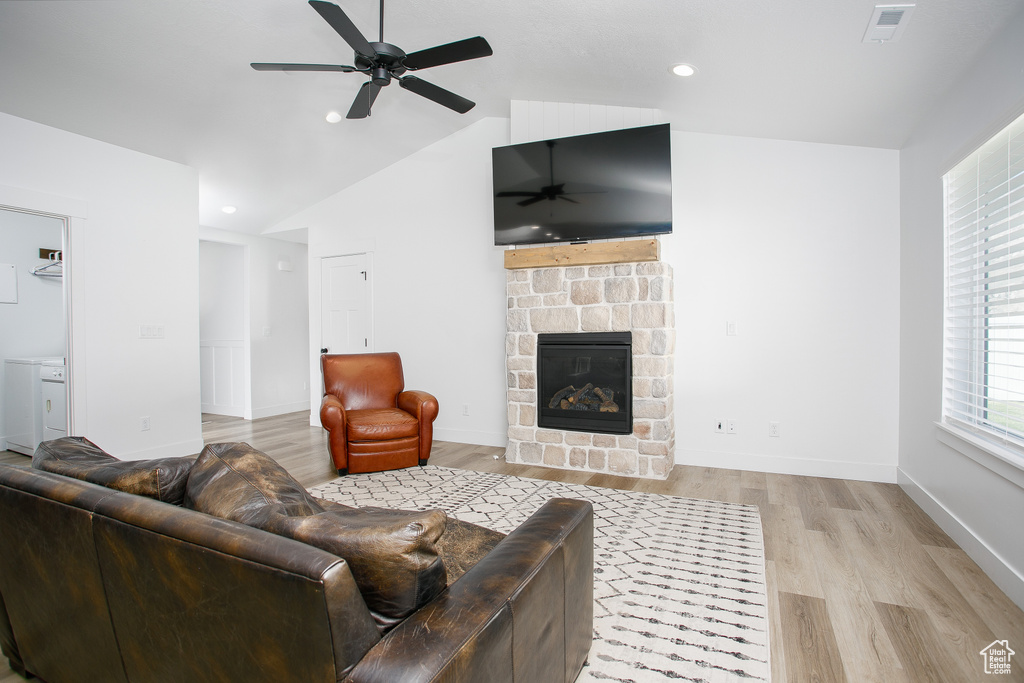 Living room featuring a ceiling fan, light wood finished floors, lofted ceiling, a fireplace, and recessed lighting