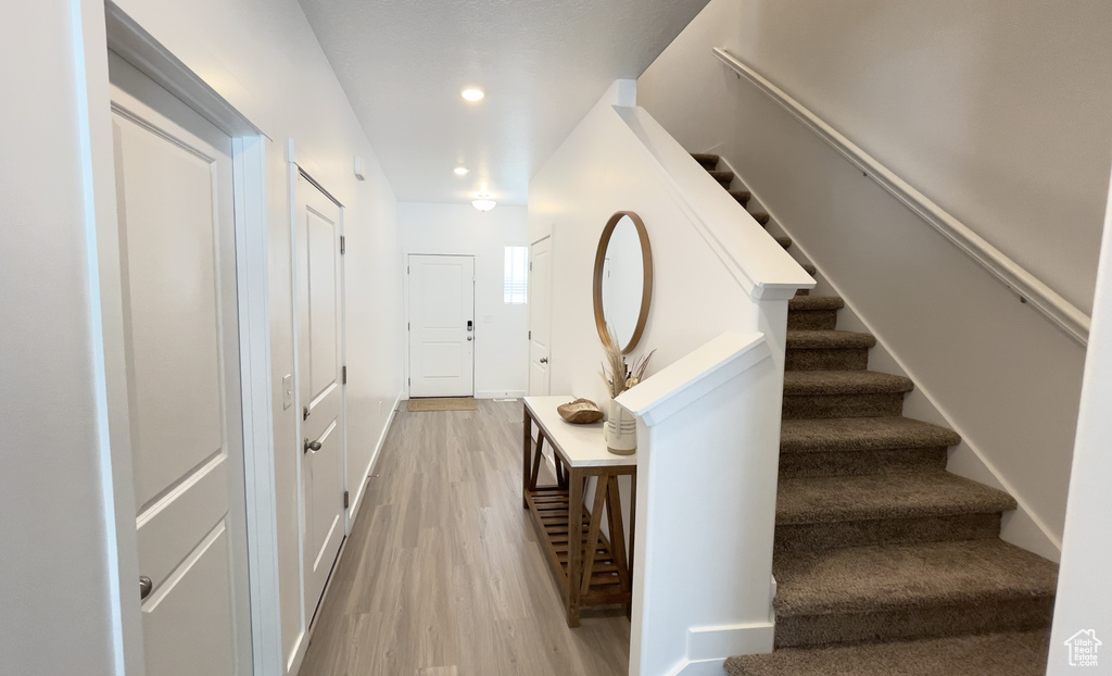 Foyer entrance featuring light wood-type flooring, stairs, recessed lighting, and baseboards