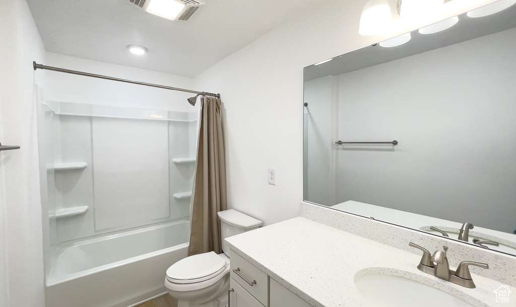 Full bath with vanity, shower / bath combo, and toilet