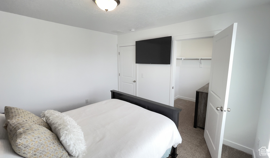 Carpeted bedroom featuring a closet and baseboards