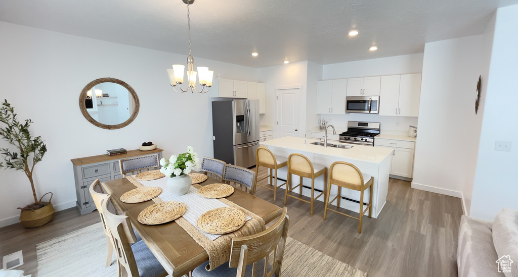 Dining space with light wood-style floors, a chandelier, recessed lighting, and baseboards
