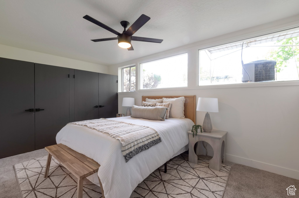 Bedroom featuring light colored carpet, baseboards, and ceiling fan