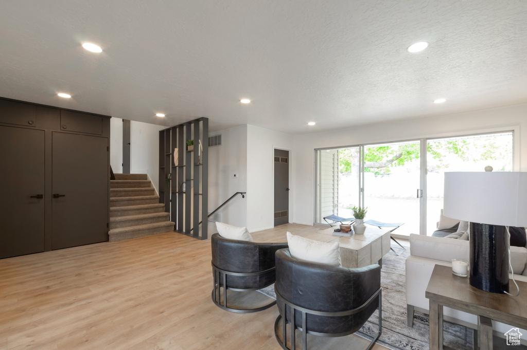 Dining area with light wood-style floors, recessed lighting, and stairs