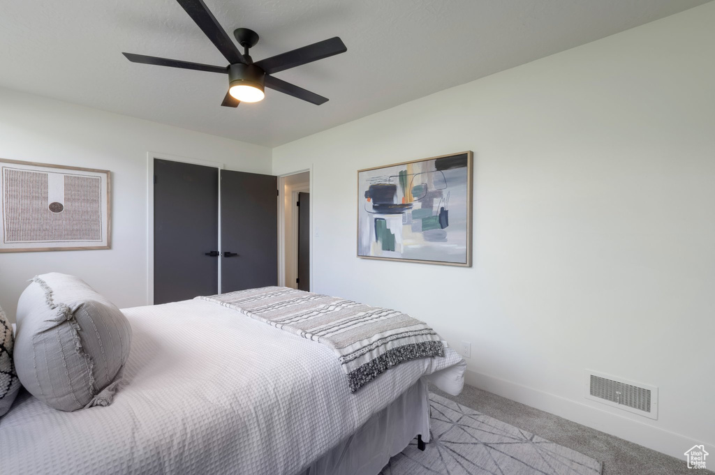 Bedroom with light carpet, baseboards, and a ceiling fan