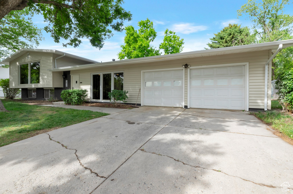 Split level home with a garage, driveway, and a front yard