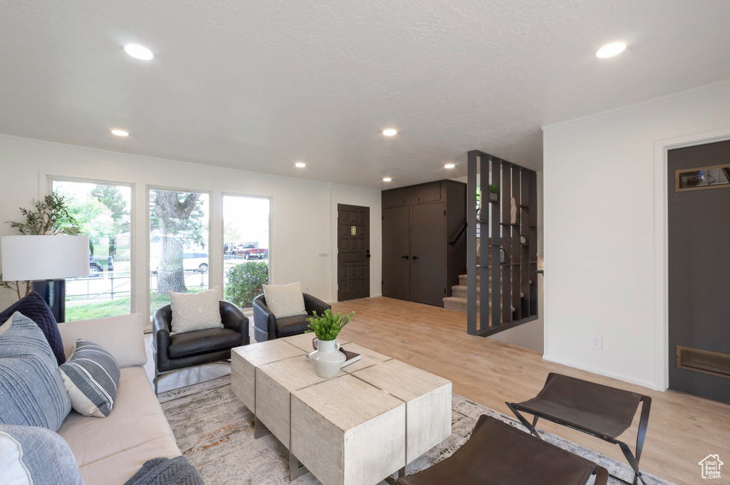 Living area with stairway, light wood-style flooring, and recessed lighting