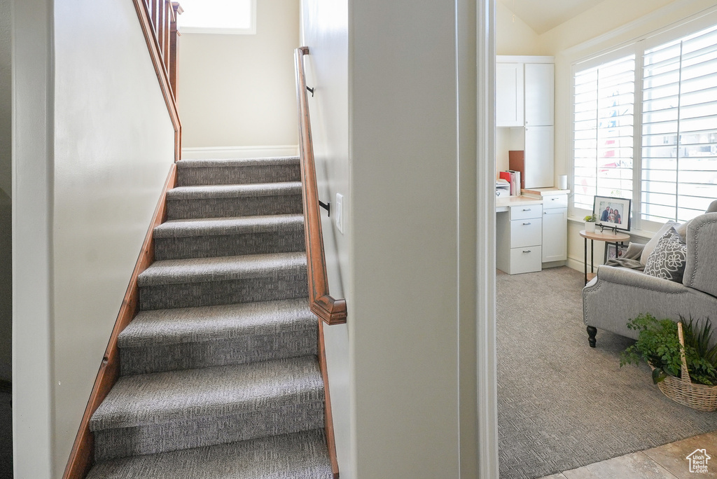 Staircase featuring healthy amount of natural light and carpet floors
