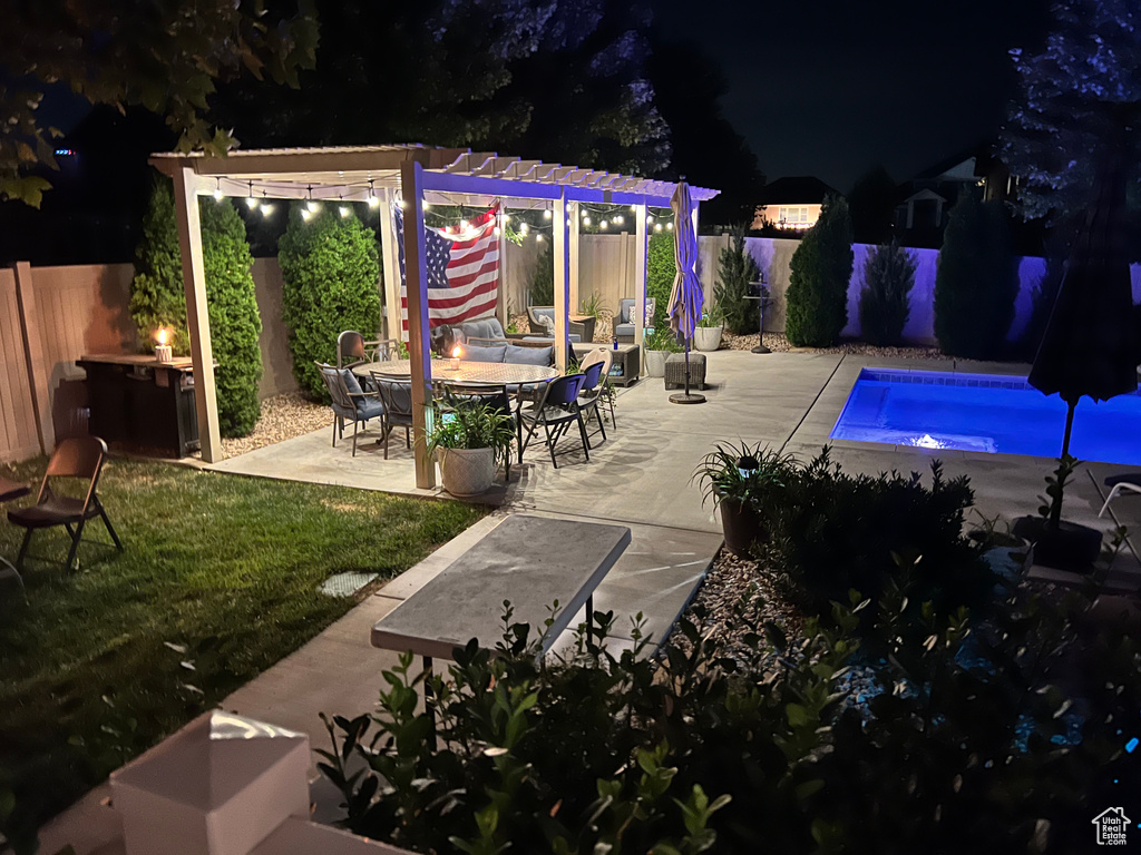 Pool at twilight featuring a patio area and a pergola