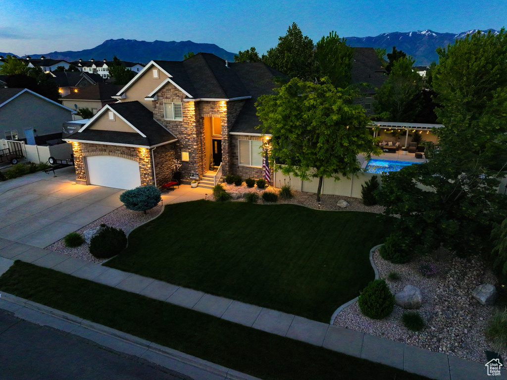 Craftsman-style home with stone siding, a mountain view, driveway, and a garage