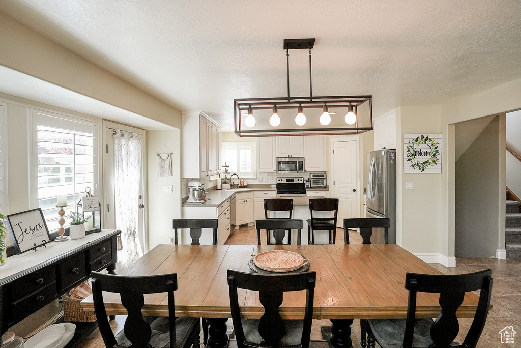 Dining space featuring stairway and light tile patterned flooring