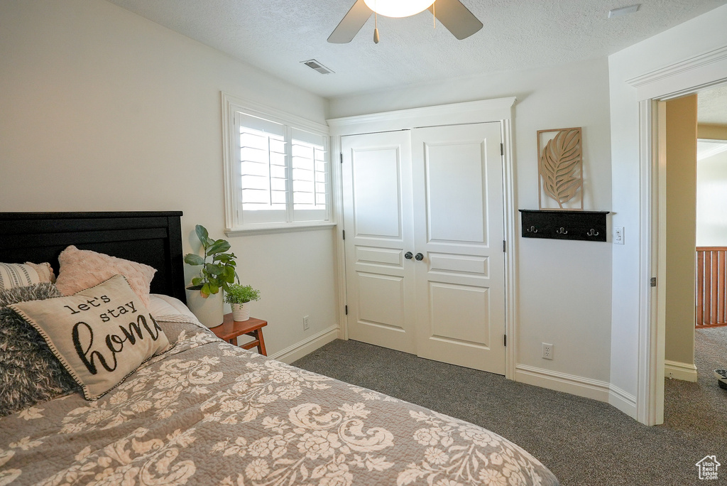 Bedroom with dark carpet, a closet, a ceiling fan, and baseboards