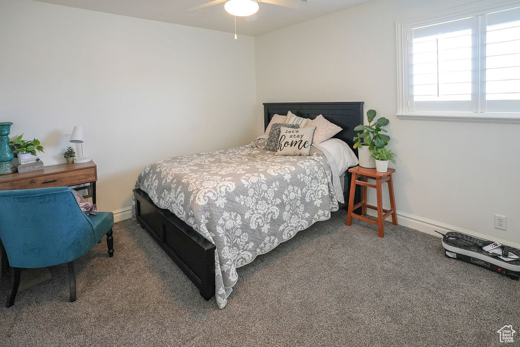 Carpeted bedroom with baseboards and a ceiling fan