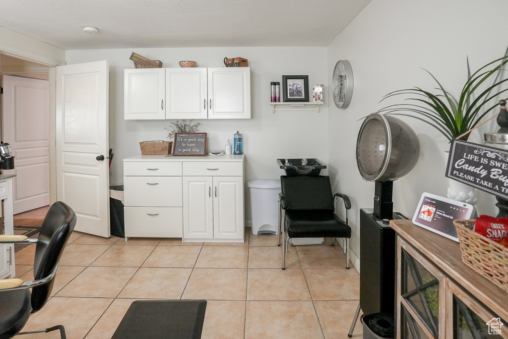 Kitchen featuring white cabinetry, light countertops, a desk, and light tile patterned floors