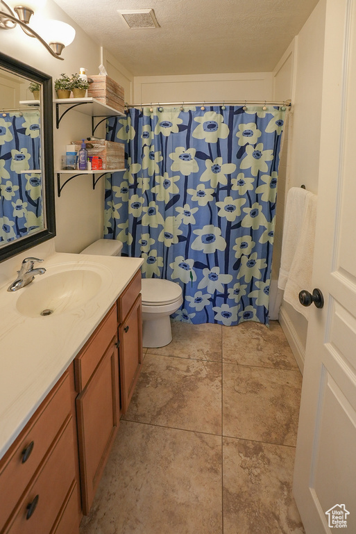 Full bath with vanity, toilet, tile patterned floors, and curtained shower