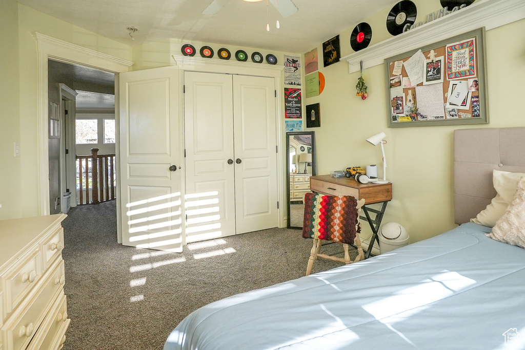 Carpeted bedroom featuring a closet and a ceiling fan