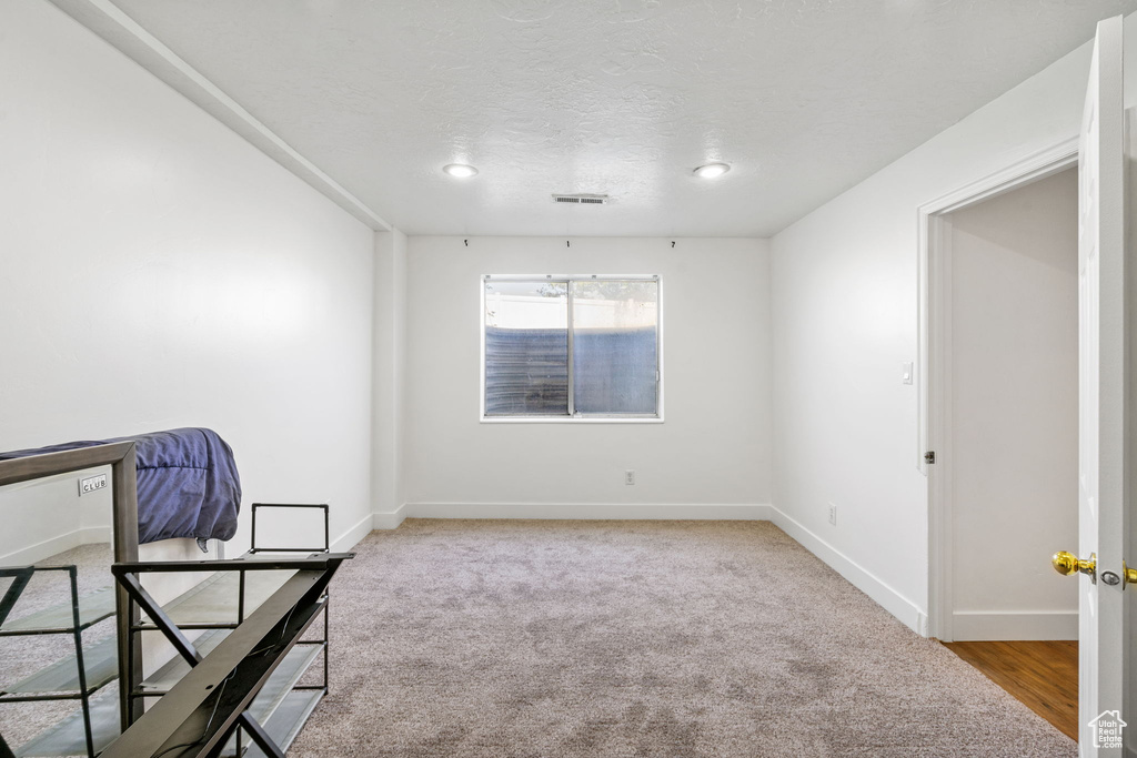 Empty room featuring baseboards, carpet floors, recessed lighting, and a textured ceiling