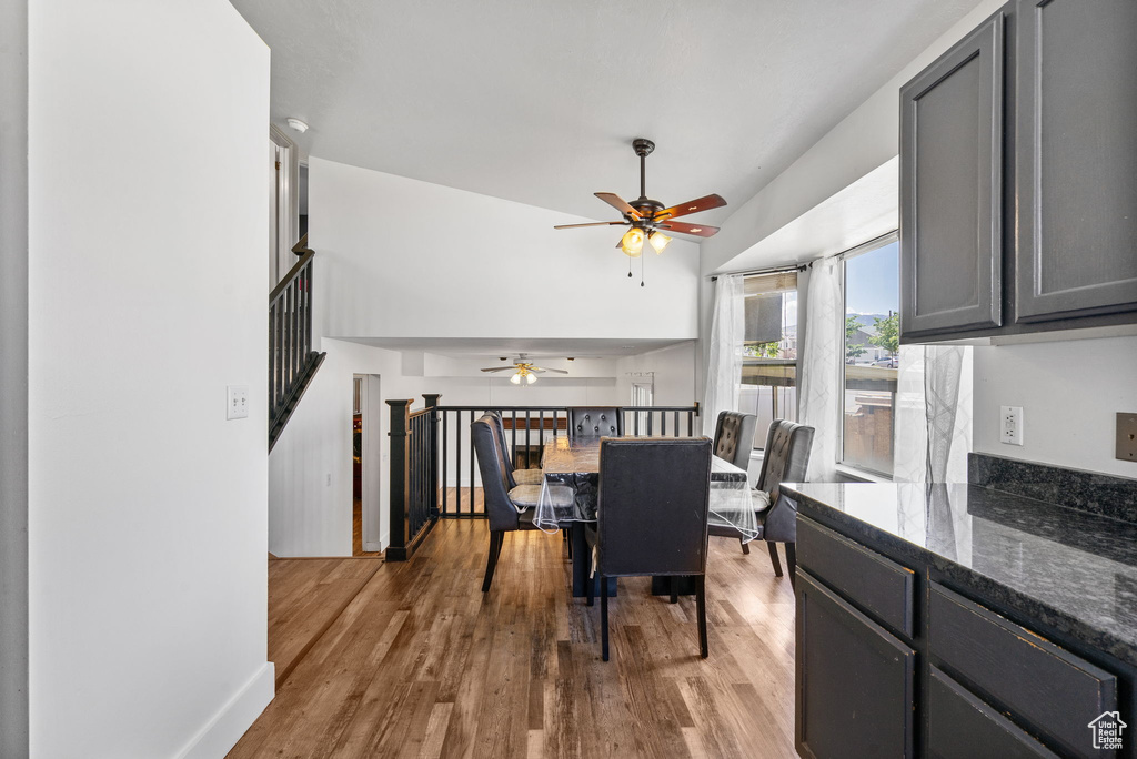Dining area featuring a ceiling fan, wood finished floors, stairs, and baseboards