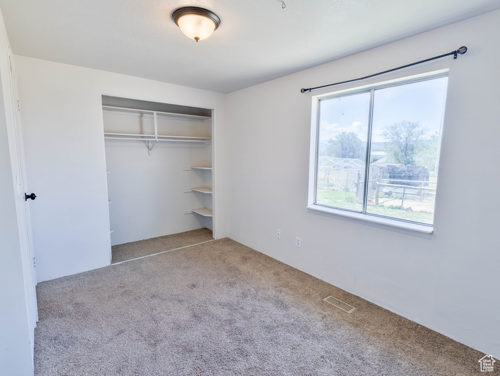 Unfurnished bedroom featuring carpet flooring and a closet